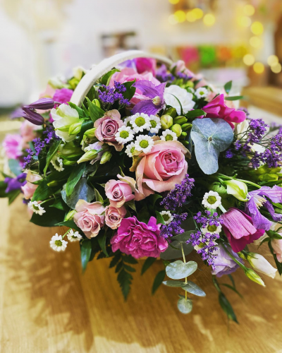 Perfect Escape - A stunning basket arrangement, created using the fresh blooms of the day in a mix of pink, purple and white with complementary foliage.